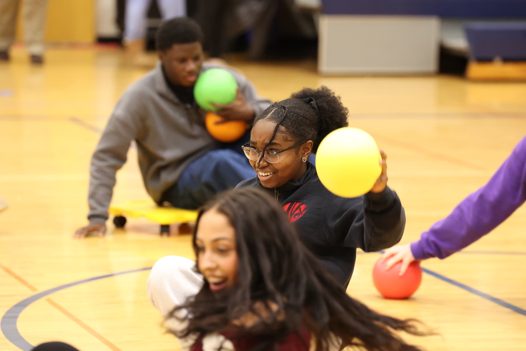 Student holds ball on scooter