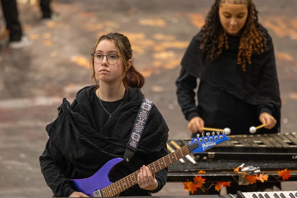 Student plays on guitar during performance