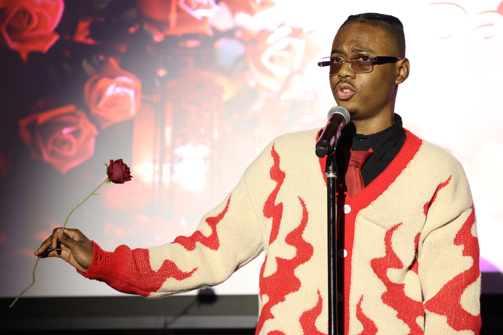 Student sings while holding rose