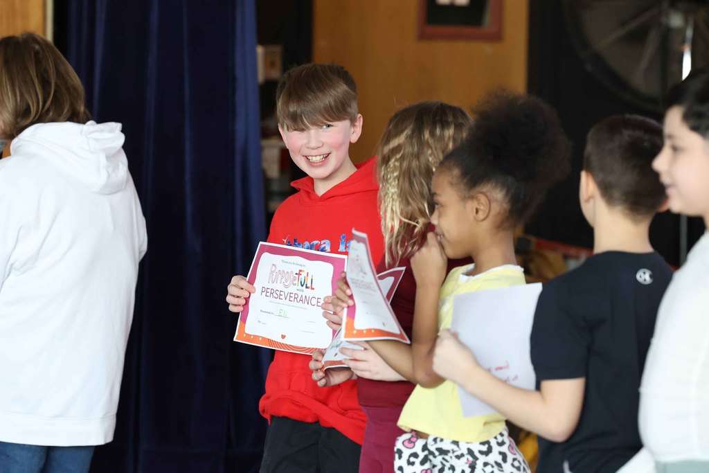 student smiles after being handed his certificate 