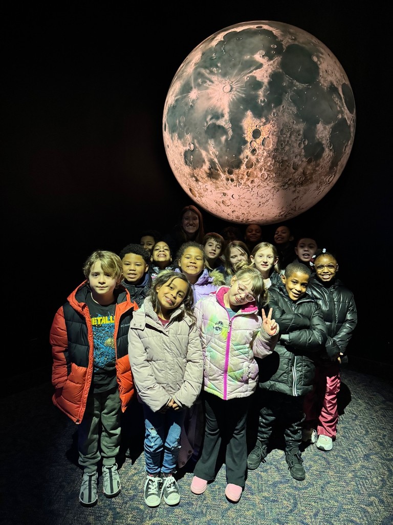 Students stand in front of the moon