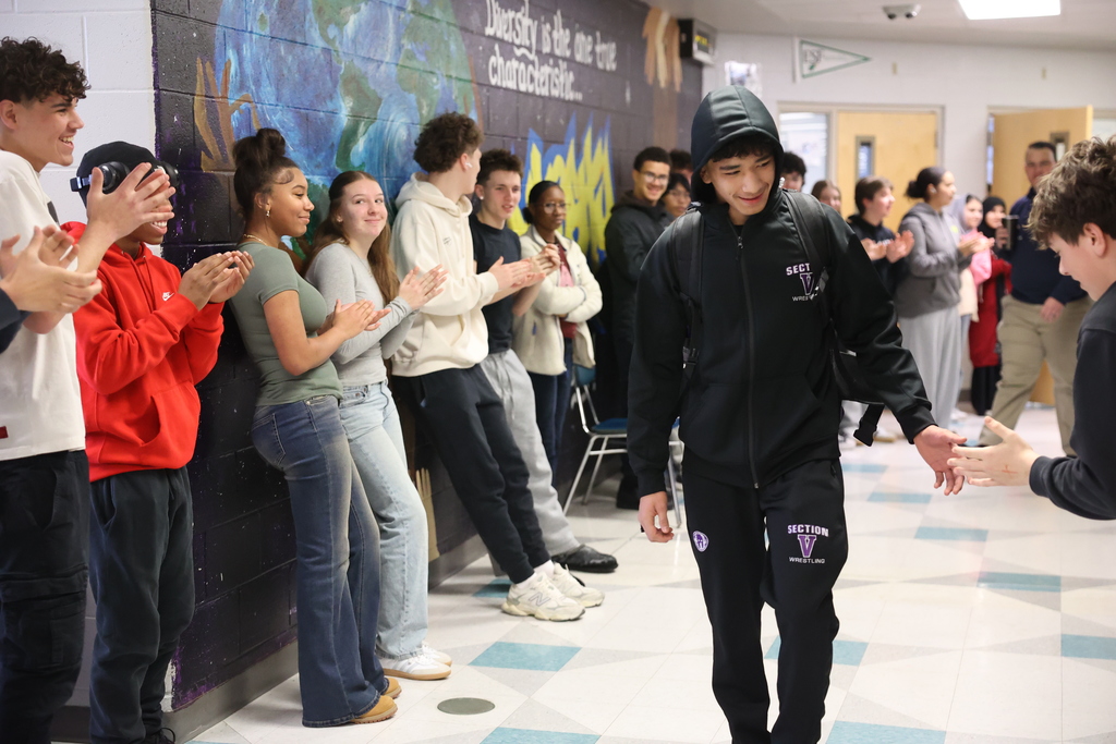 student goes to high five friend in hallway