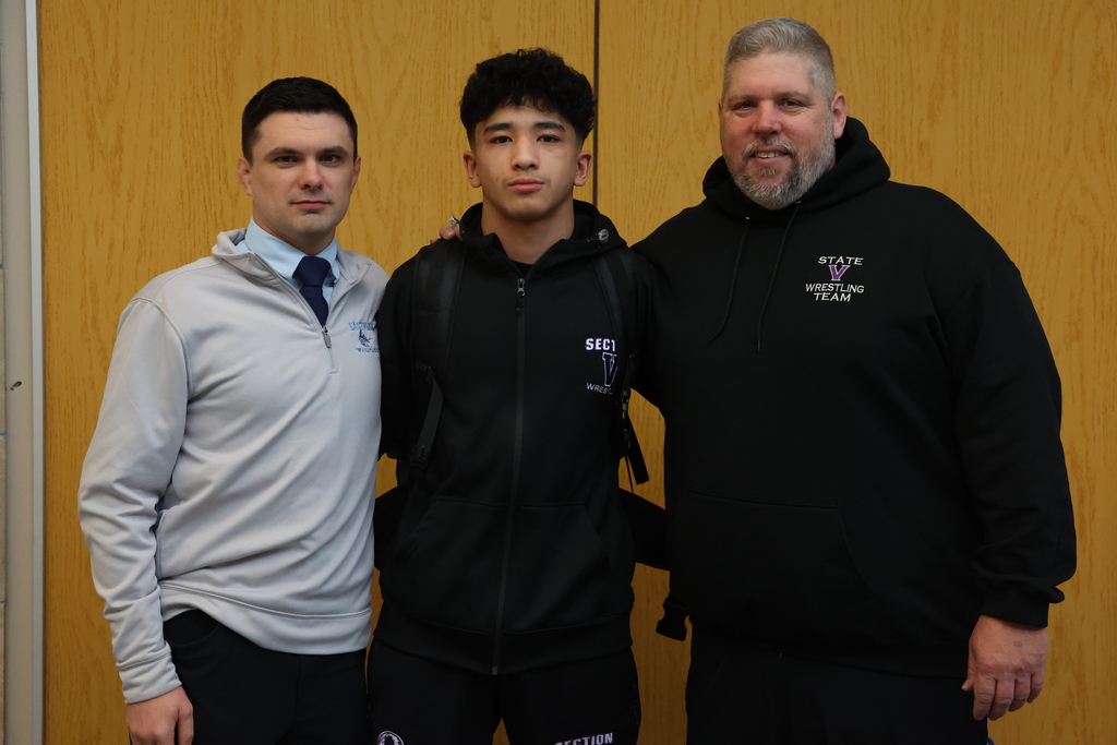 coaches and player pose for a photo