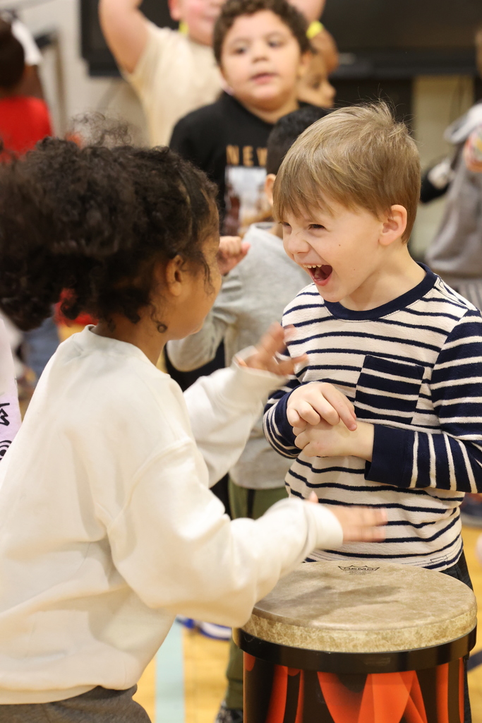students laugh while playing the drum