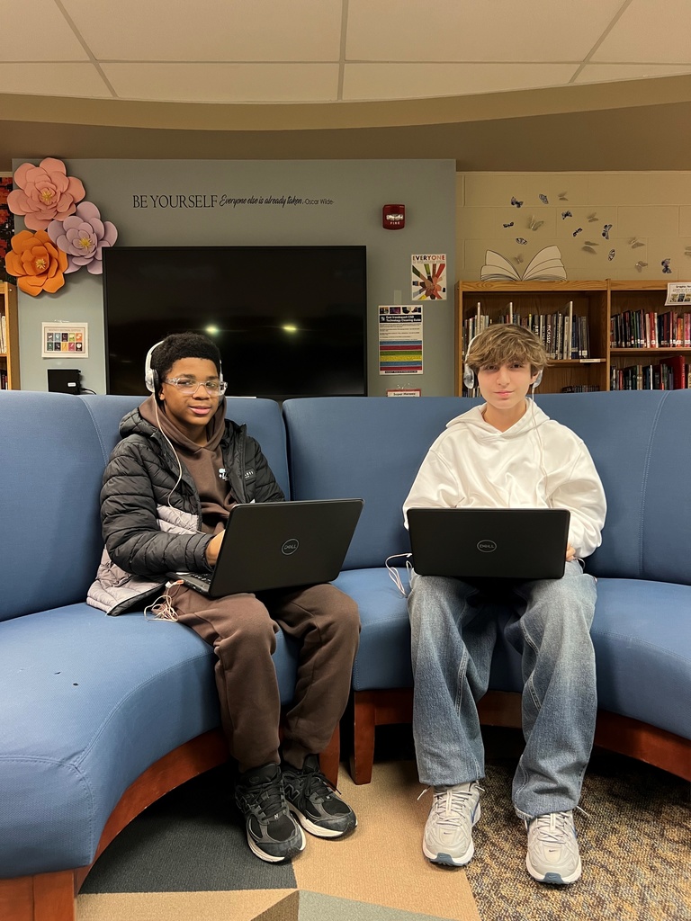 Students sit on couch with laptops and headphones