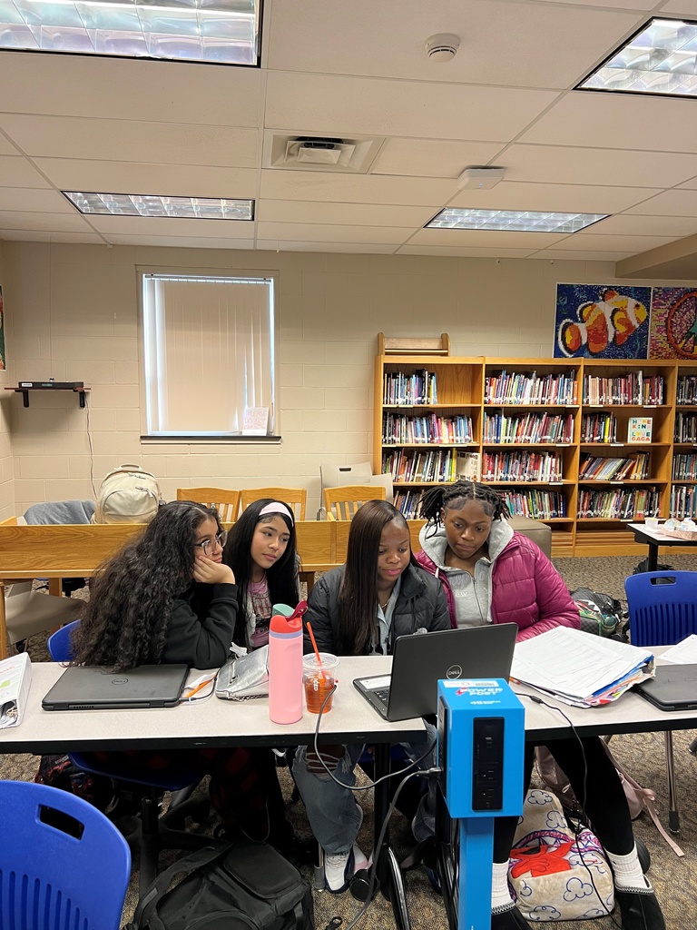 students gather around a computer to virtually chat