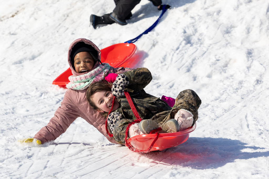 Kids playing in the snow and sledding