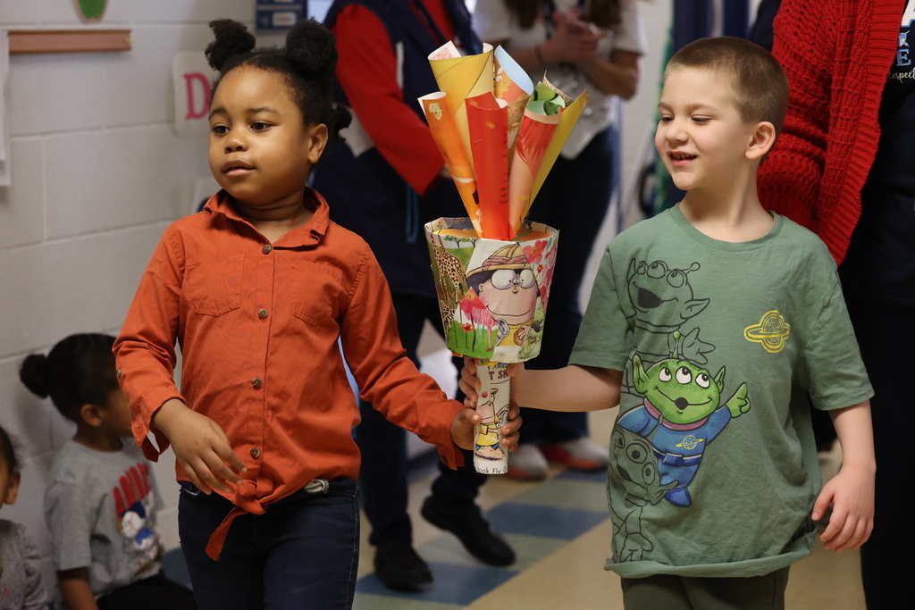 students hold torch as they walk