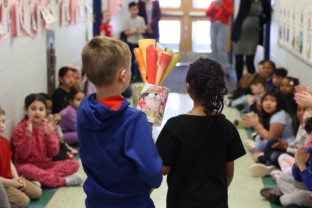 student hold paper torch as they walk through the halls