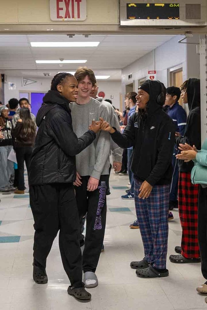 Students cheering on the athletes as they walk through the halls.