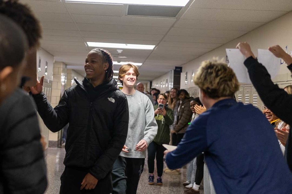 Students cheering on the athletes as they walk through the halls.