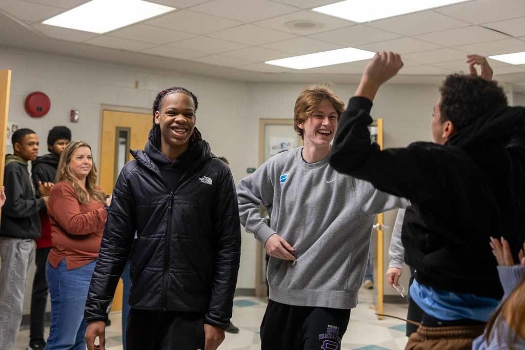 Students cheering on the athletes as they walk through the halls.