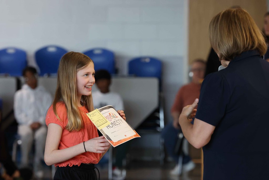 student smiles with award