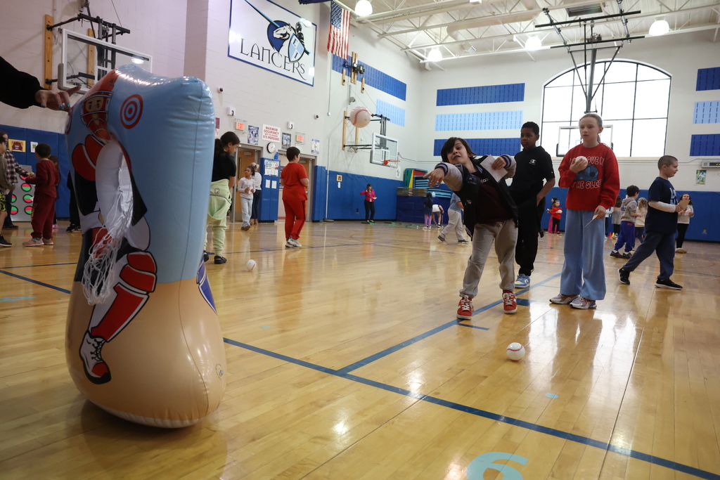 student throws baseball at fake blow up catcher net