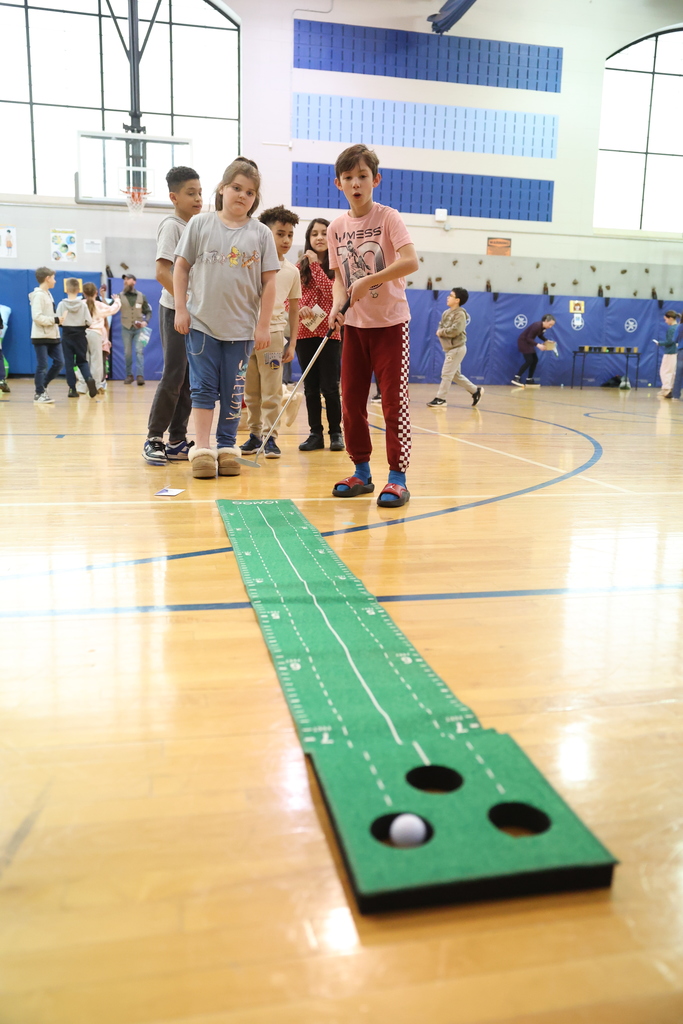 student is suprised to get a hole in one during putt putt golf