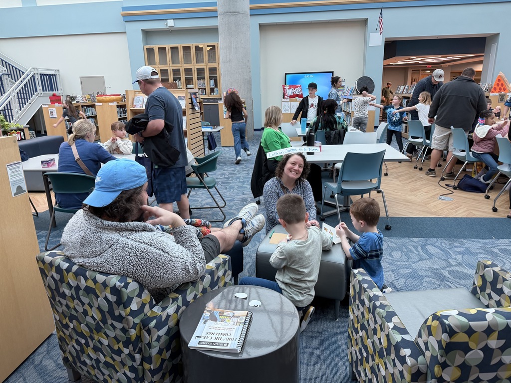 Students and families participate in games and fun in the library during Spring into Literacy Night