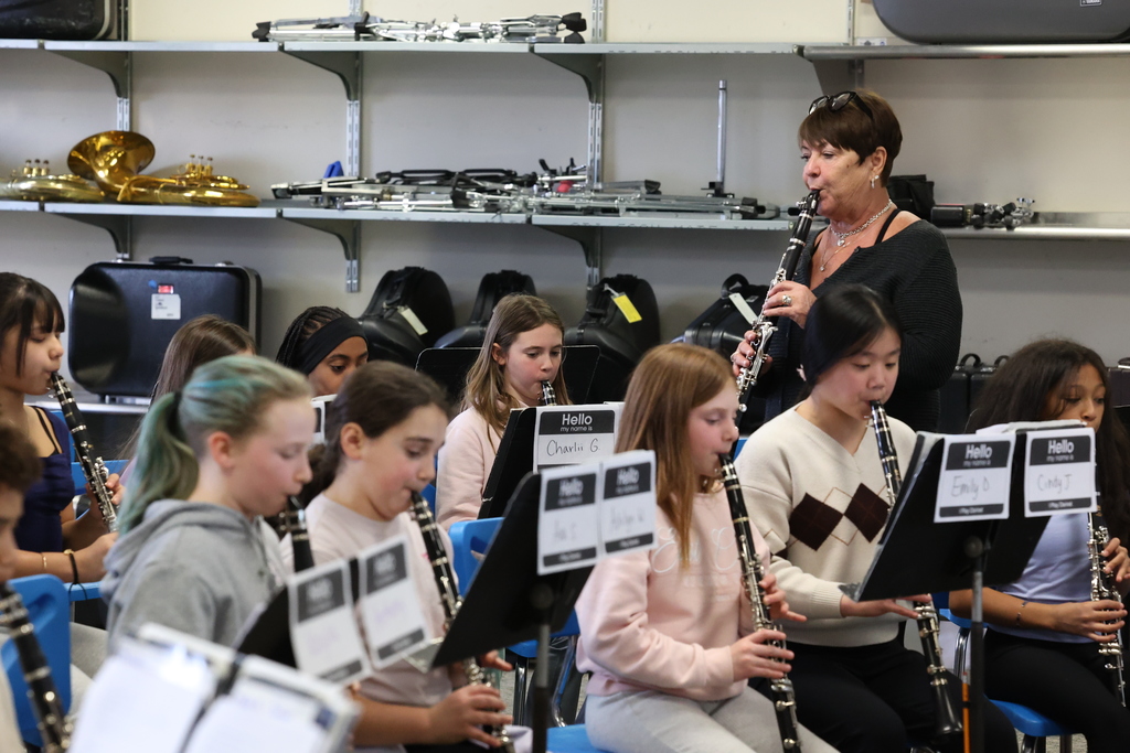 Students play the clarinet with teacher