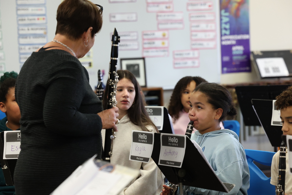 student plays clarinet for instructor