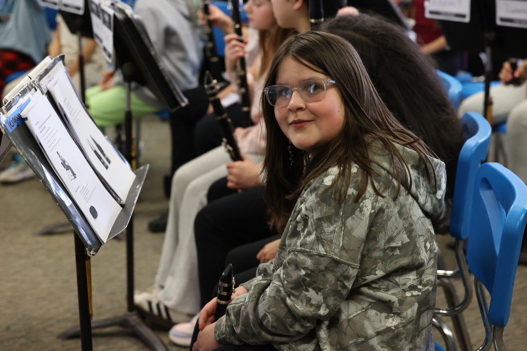 student smiles with clarinet in chair