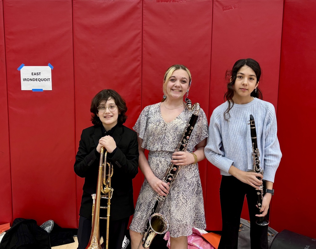 Students smile with instruments for photo