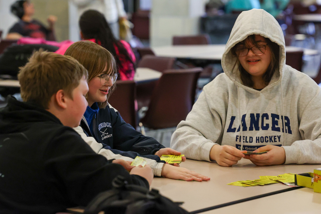 Students play cards at a table