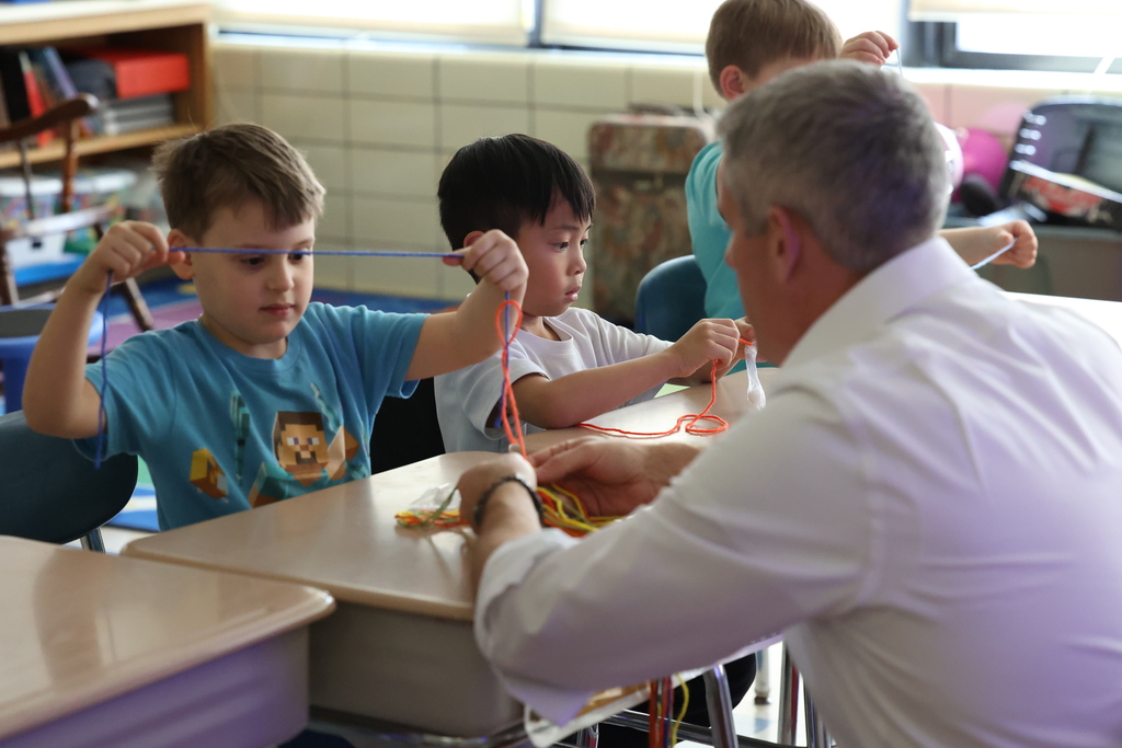 Student looks at string with visitor