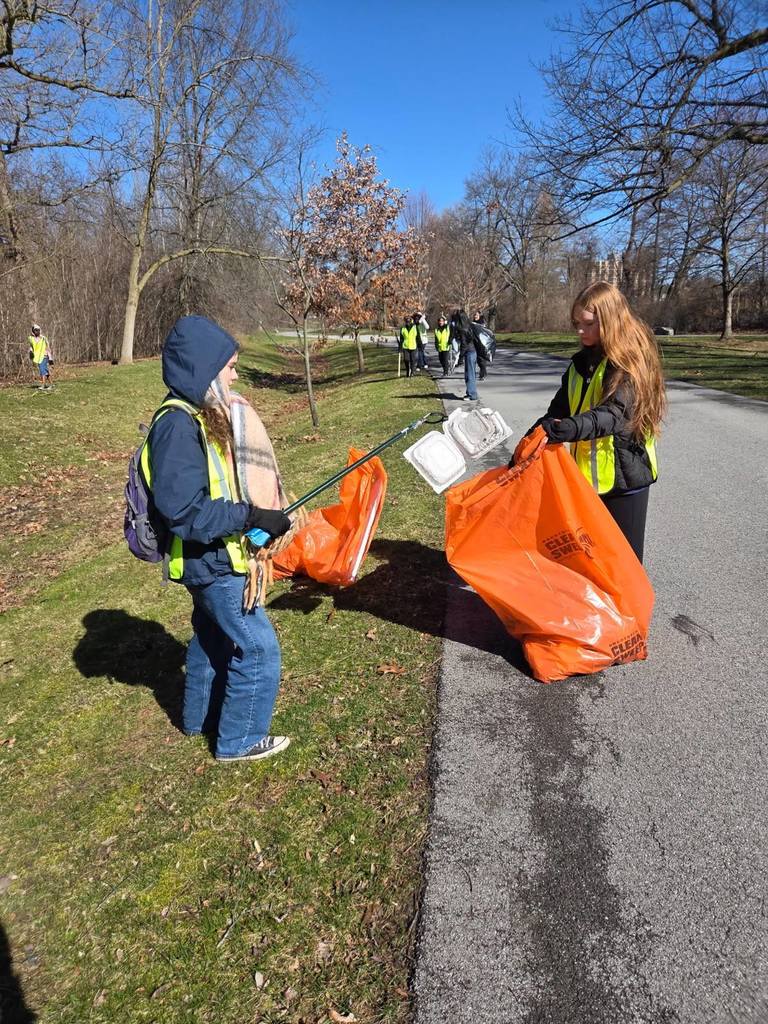 Students participating in give back day cleaning up the community and working with children