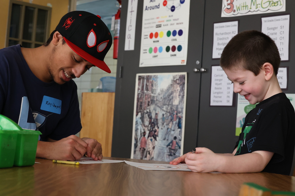 Students participating in give back day cleaning up the community and working with children