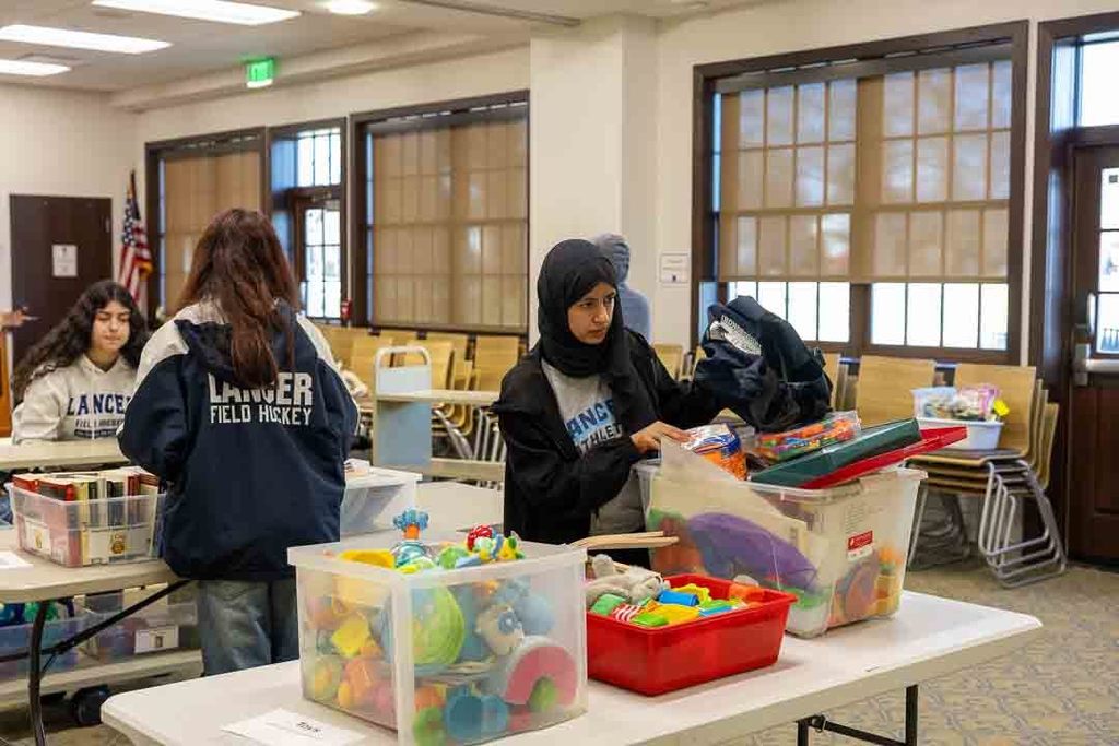 Students participating in give back day cleaning up the community and working with children