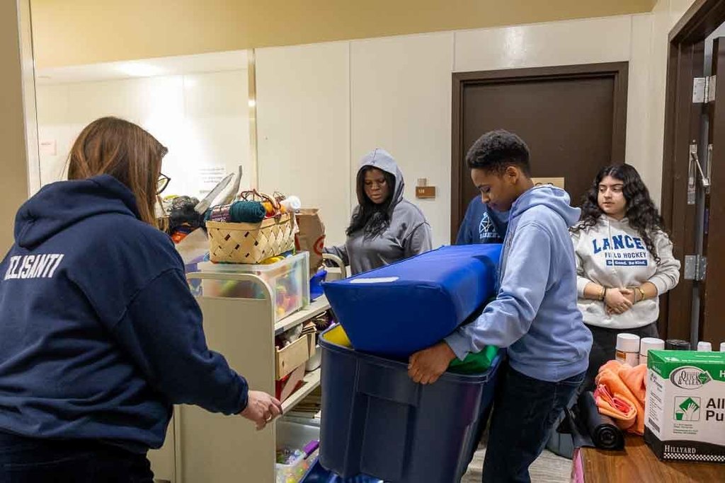 Students participating in give back day cleaning up the community and working with children
