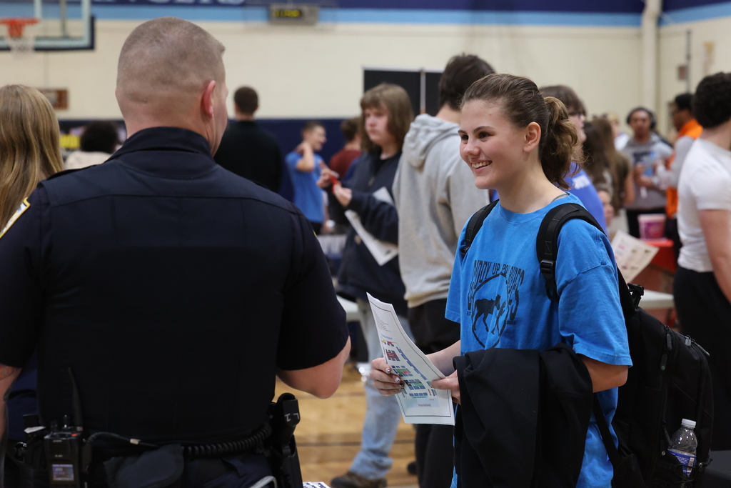 student smiles at career fair table