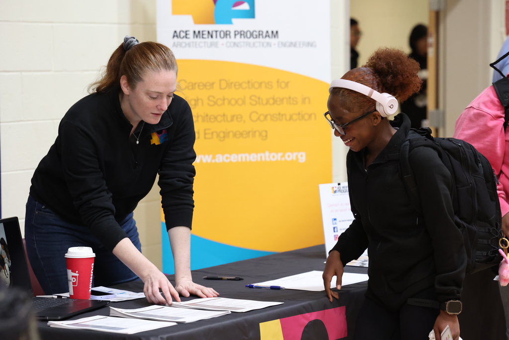 Student talks to Ace Mentor employee at table