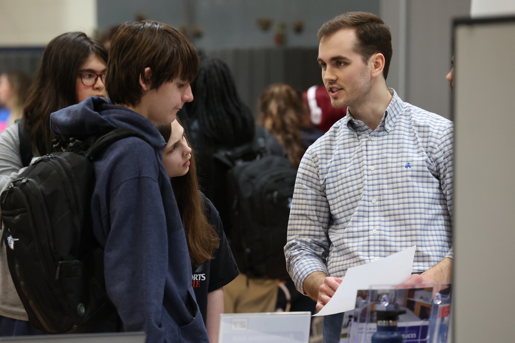 student talks to career fair visitor 