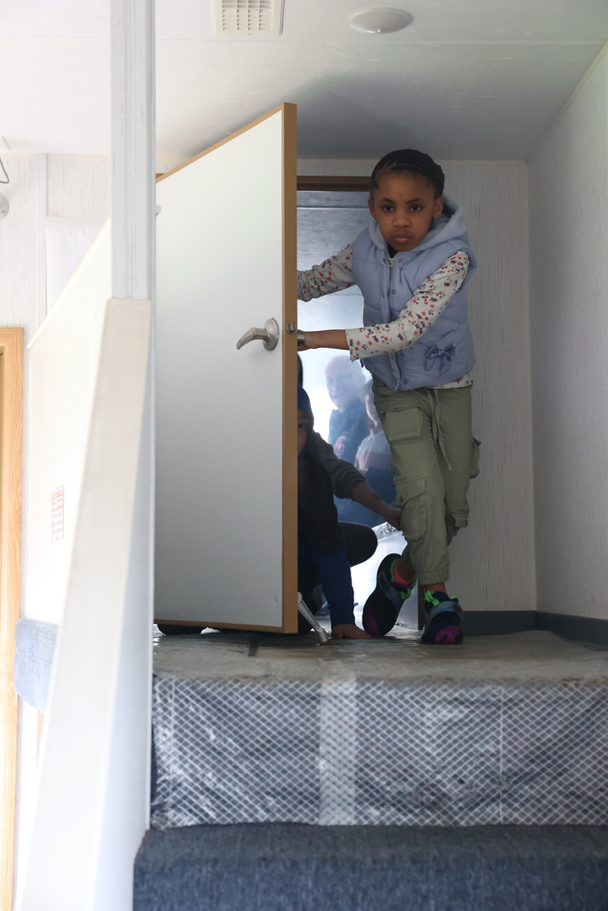 student opens door cautiously 