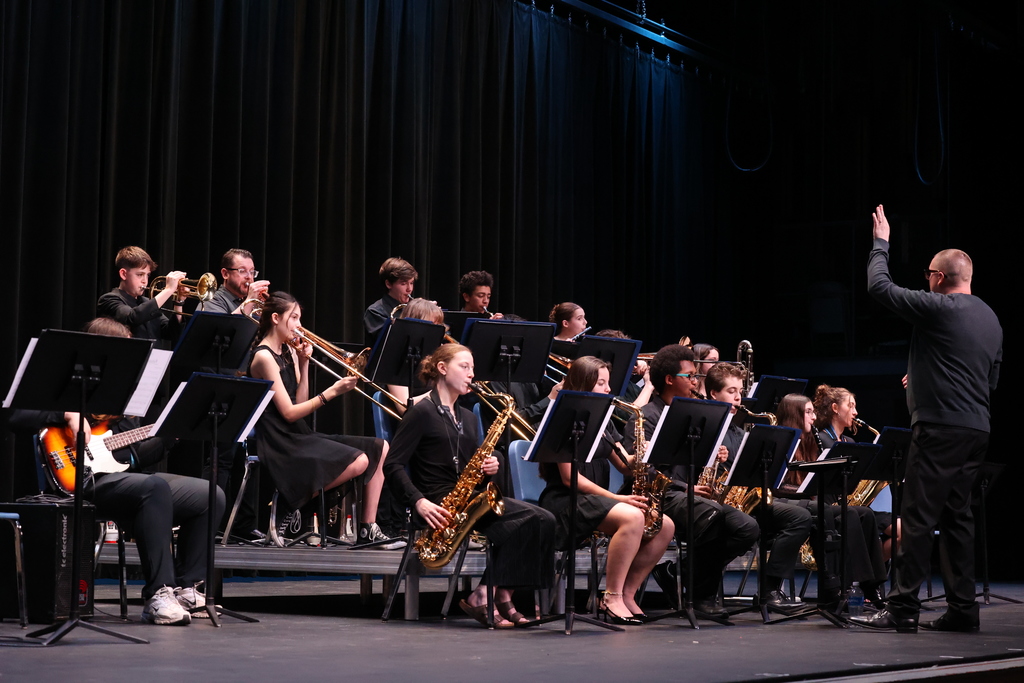 students perform jazz music on stage with conductor 