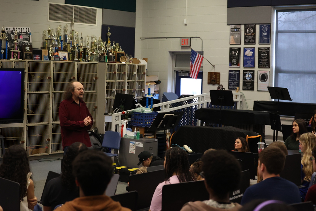 visitor talks to students in music room about his career