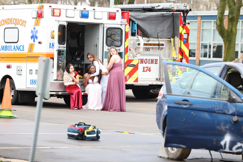 students act from an ambulance car in prom dresses that they were in a car accident