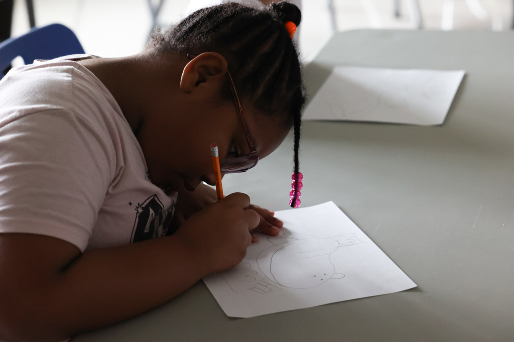 Student draws cartoon with pencil