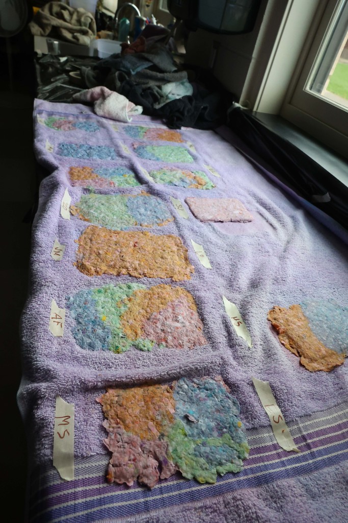 colorful homemade paper drying on a towel 