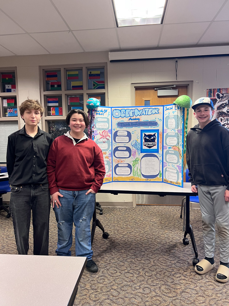 students stand with presentation board on made up college called deepwater academy 