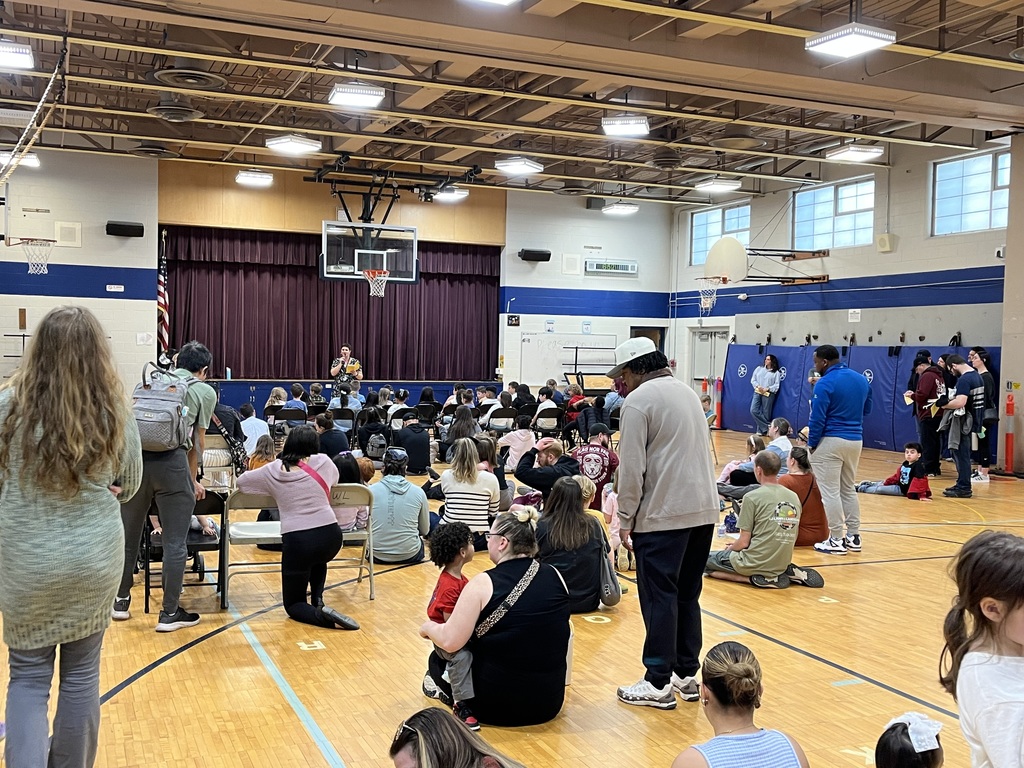 students and families gather in the gym to listen to the first chapter of the book 