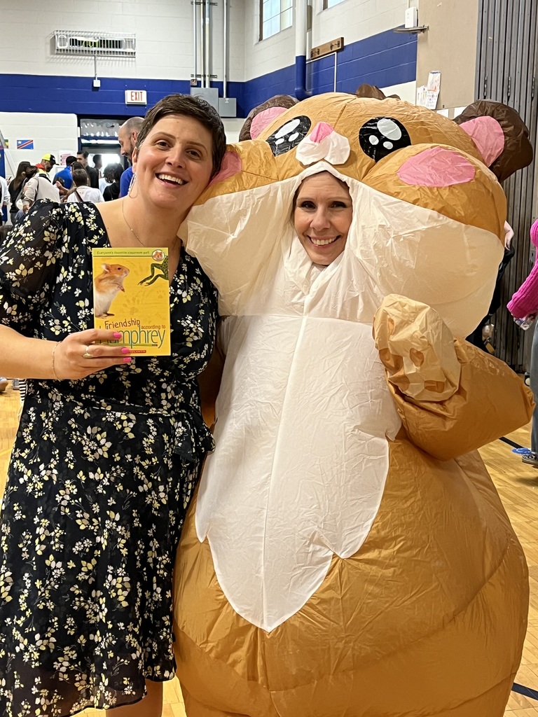 Friendship with Humphery book held by principal and office secretary dressed up as a blow up hamster