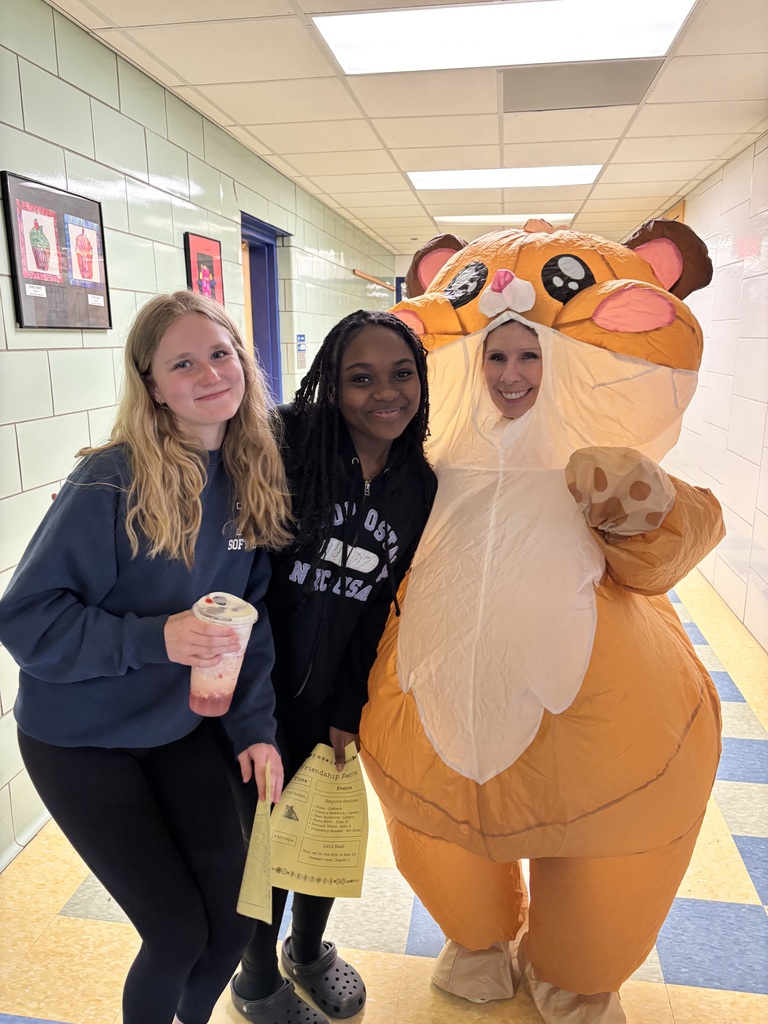 students pose with office secretary dressed up as a hamster