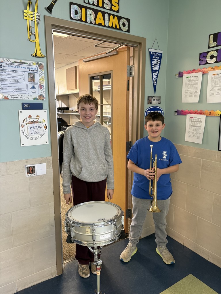Two students with the drum and trumpet smile for a picture