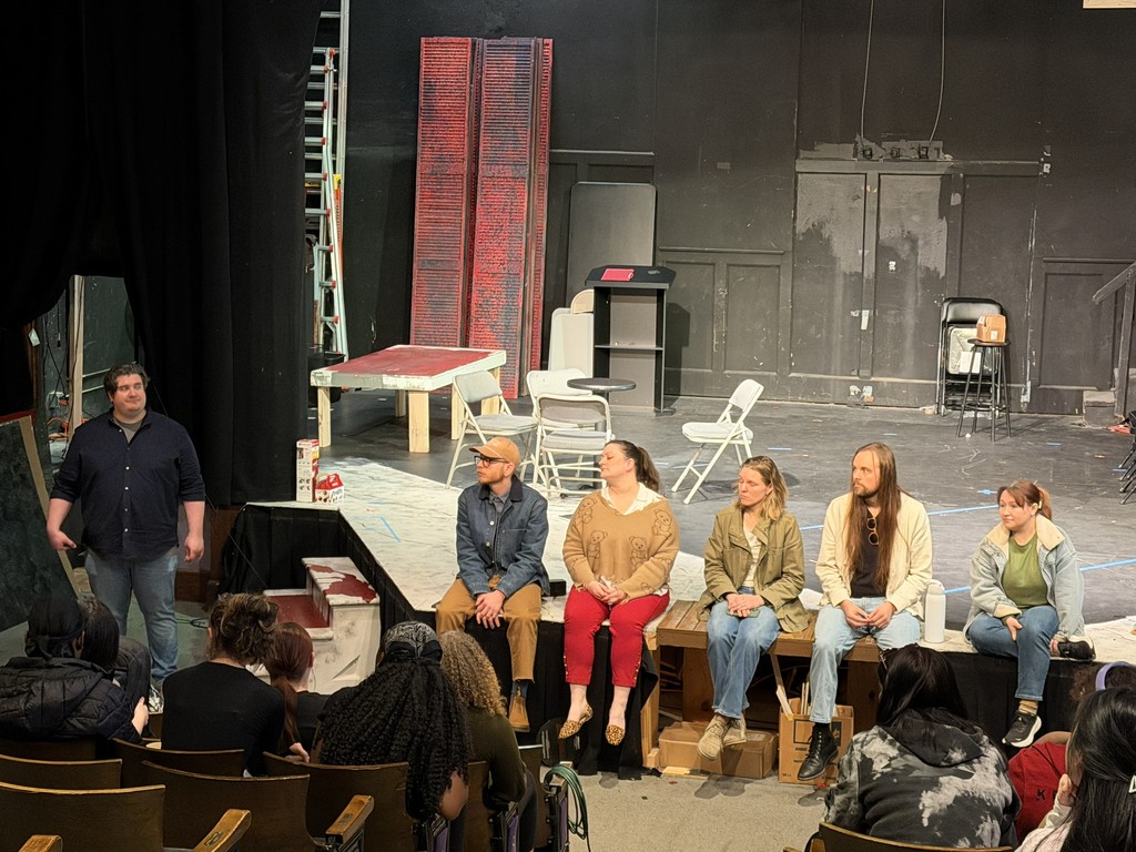 musical professionals sit on stage and answers questions from students