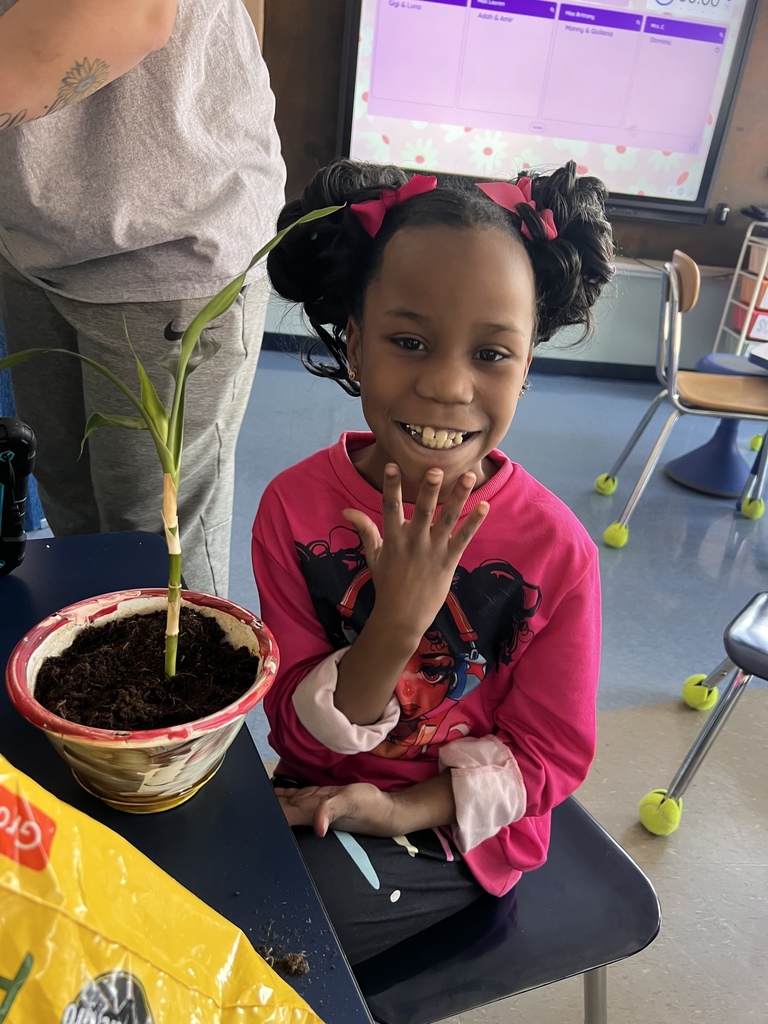 student smiles with potted plant
