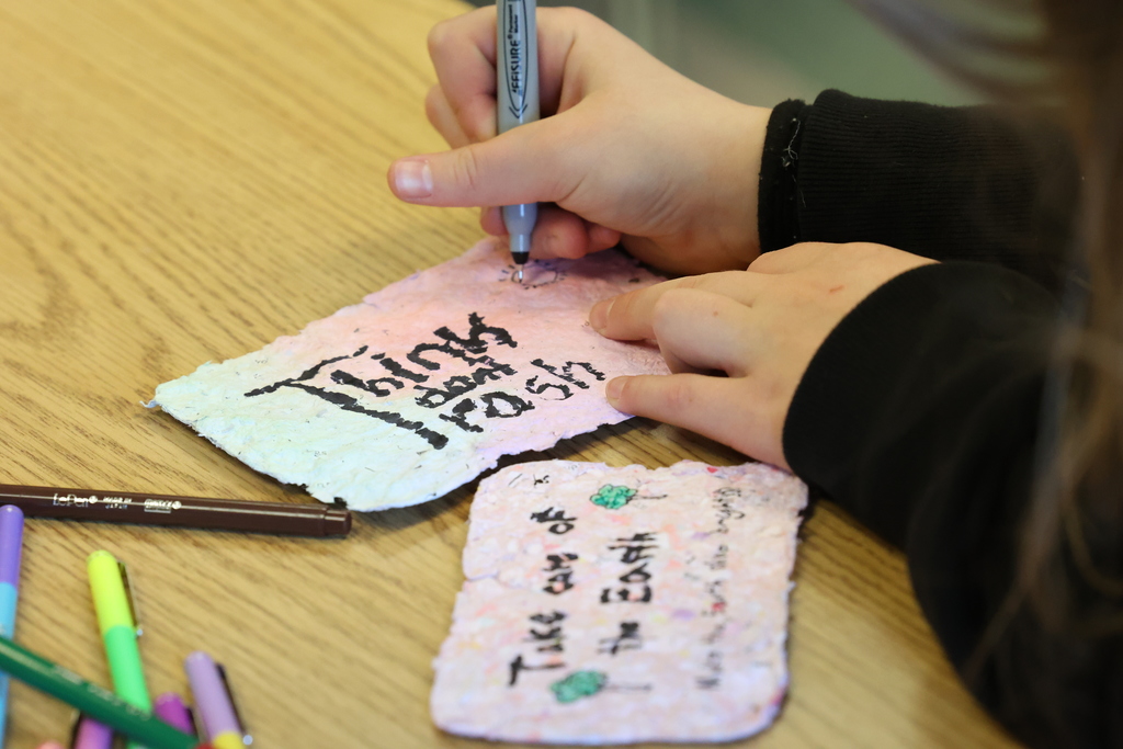 student writes on homemade paper thing dont trash