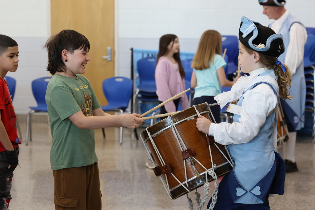 students takes drum sticks and plays instrument while student performer holds