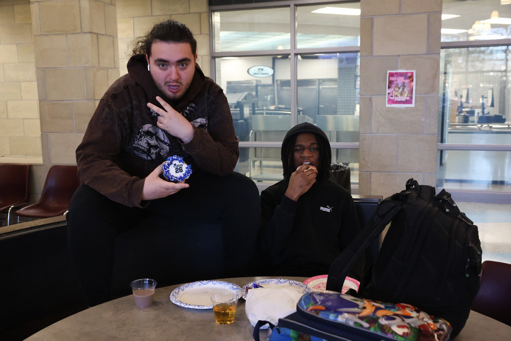 students pose with donuts for senior breakfast