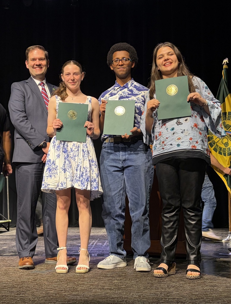 three EI students hold up awards and pose for a photo with Monroe County Legislator 